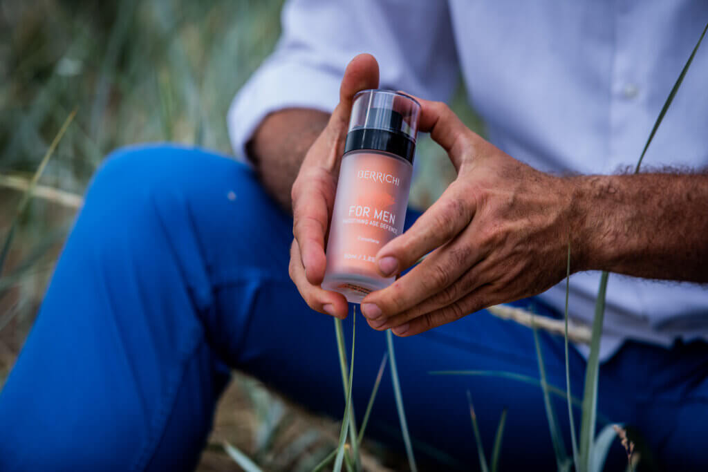 Mees istub, hoiab käes Berrichi meeste näokreemi